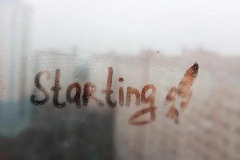 Lettering word starting and shape of space rocket on foggy glass window on blue Stock Photos