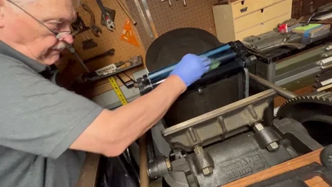 Letterpress printer cleans his press rollers Stock Footage 219111415