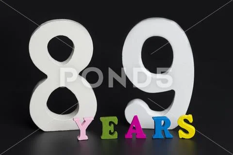 Letters and numbers eighty-nine years old on a black background. Stock Photos