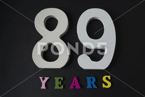 Letters and numbers eighty-nine years old on a black background. Stock Photos