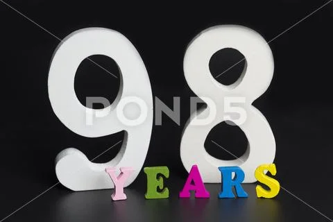 Letters and numbers ninety-eight years old on a black background. Stock Photos