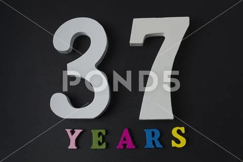Letters and numbers thirty-seven years on a black background. Stock Photos