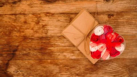 Letters in craft paper envelopes and a gift of roses on wooden background Stock Photos