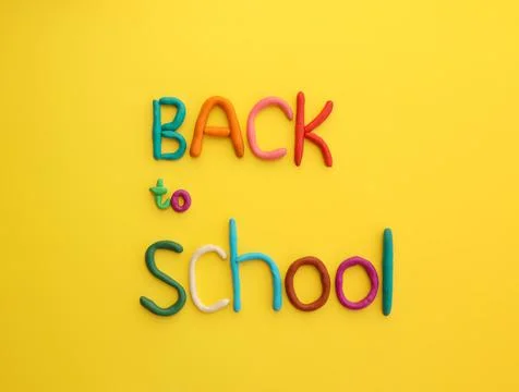 Letters made of multi-colored plasticine back to school on yellow background Stock Photos