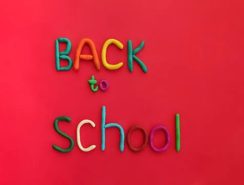 Letters made of multi-colored plasticine back to school on red background Stock Photos