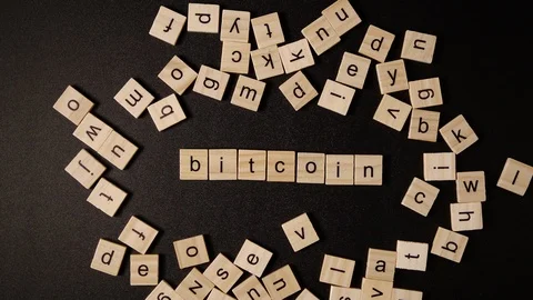 Letters move and sets up a word «Bitcoin» on a black table Video stock 120163039
