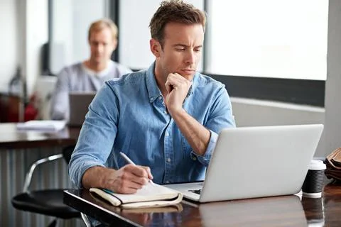 Letting his creativity work for him. a man working on a laptop in an office. Stock Photos
