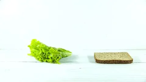 Lettuce and bread slice on a white wooden surface Stock Photos