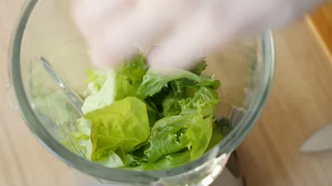 Lettuce, cucumber, green celery are added to the mixer to make a wellness Stock Footage 178484496