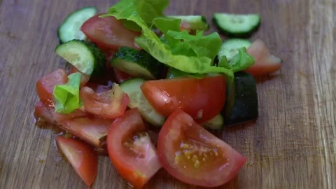 Lettuce leaves fall on the vegetables lying on the table Видео 132387144