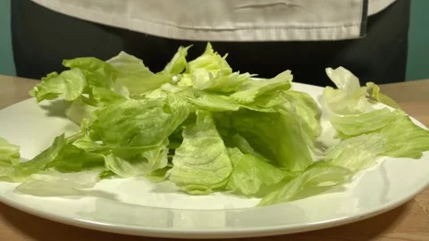 Lettuce leaves fall on a white plate 库存影片 306803348