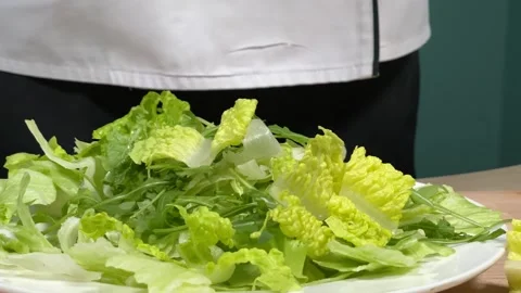 Lettuce leaves fall on a white plate Stock Footage 306803473