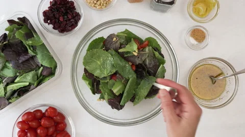 Lettuce salad with cherry tomatoes, dry cranberries, nuts and mustard dressing Stock Footage 138539280