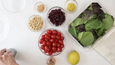 Lettuce salad with cherry tomatoes, dry cranberries, nuts, and mustard dressing Stock Footage 138540607