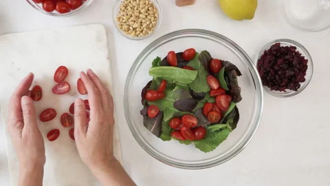 Lettuce salad with cherry tomatoes, dry cranberries, nuts, and mustard dressing Stock Footage 138541553