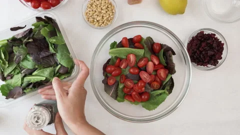 Lettuce salad with cherry tomatoes step by step recipe. Bowl of fresh ingredient Stock Footage 144483810