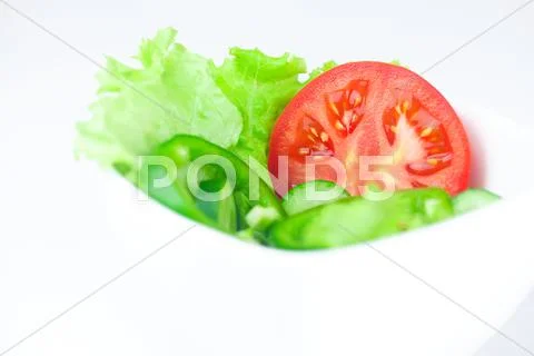 Lettuce, tomato, cucumber and pepper in a bowl isolated on white Stock Photos