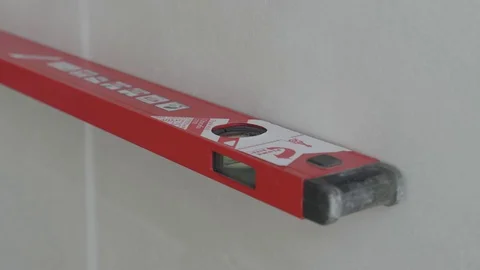 Level checks the walls after plastering Stock Footage 130050016