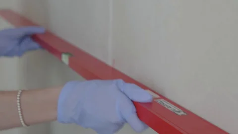 Level checks the walls after plastering Stock Footage 130050030