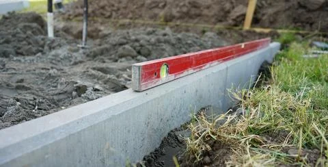Level on the concrete kerb. Leveling on the construction site. Work zone. Stock Photos