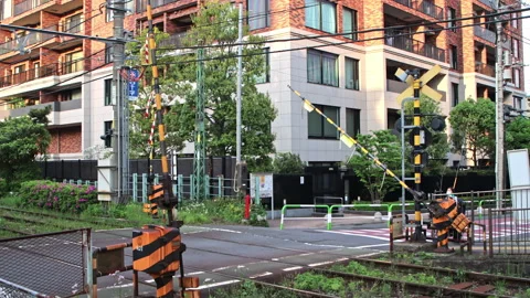 Level Crossing Barrier lowered to block traffic for incoming tram or streetcar Stock-Footage 185641357