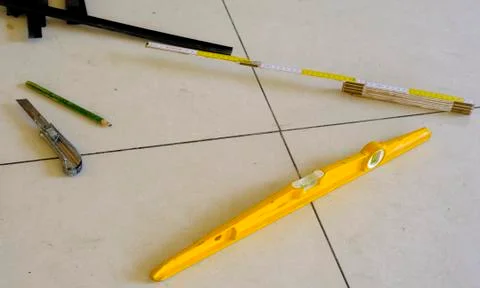 Level, utility knife, strips, eec. tools work for a floating floor on steel f Stock Photos