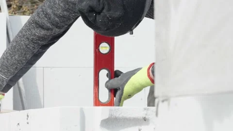 Leveling bricks with the help of a spirit level during the construction of the Stock Footage 239005708