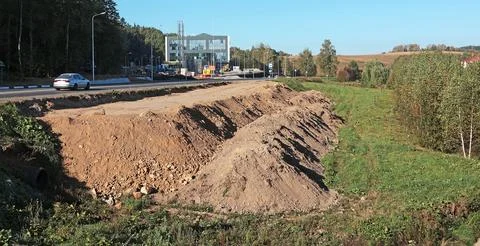 Leveling ground for construction of bus stop. Piles of earth on construction Stock Photos