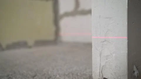 Leveling the wall with a laser level. Lighted laser level. Display perpendicu Stock Photos