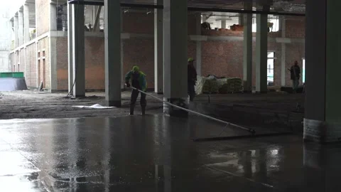 Levelling concrete floor.  Construction work inside of giant warehouse Stock Footage 218471349