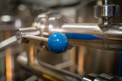 Lever handle with a blue ball on the background of beer equipment Stock Photos