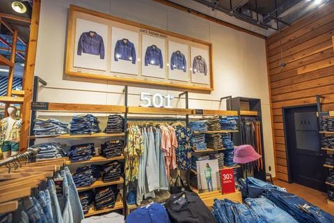 Levi’s retail store interior featuring stacked jeans, wooden shelves Stock Photos