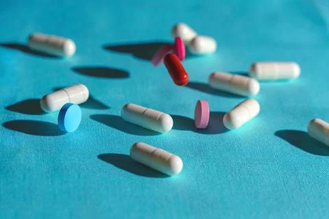 Levitating and reclining tablets of different shapes and colors on a blue bac Stock Photos