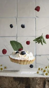 Levitating cake with berries on a light background, vertical orientation Stock Photos
