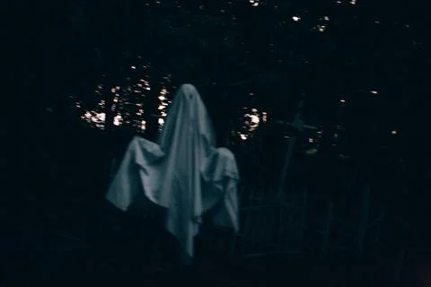 Levitating ghost in the cemetery between graves during Halloween Stock Photos