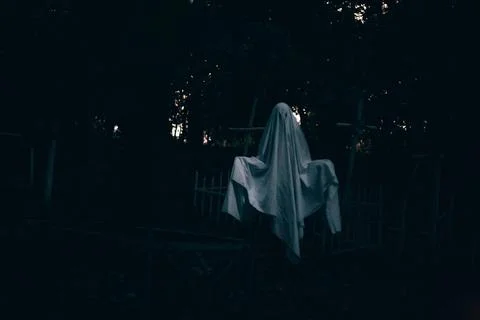 Levitating ghost in the cemetery between graves during Halloween Stock Photos