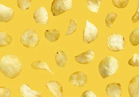 Levitating potato chips on yellow background Stock Photos