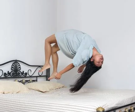 Levitating woman flying over the bed Foto stock