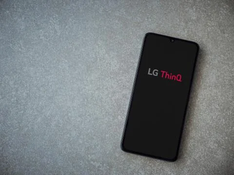 LG ThinQ app launch screen with logo on the display of a black mobile smartph Stock Photos