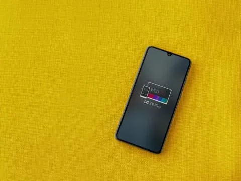 LG TV Plus app launch screen with logo on the display of a black mobile smart Stock Photos