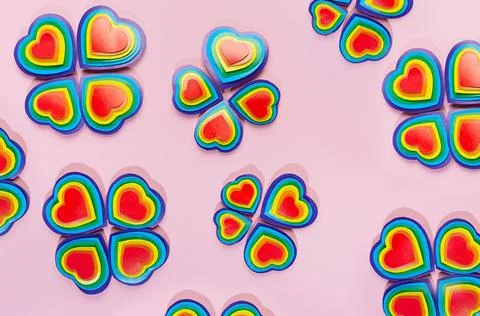 Lgbt background - pattern as flower shape of rainbow hearts on pastel pink ba Stock Photos