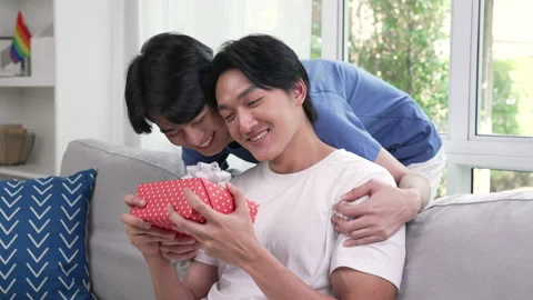 LGBT couple feeling happy while giving and receiving gifts from partner. Stock Footage 217454909
