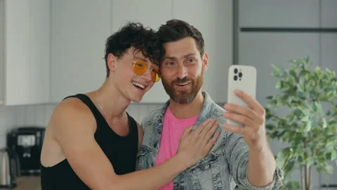 Lgbt gays smiling couple using the smartphone for video call to tell good news Stock Footage 204776227