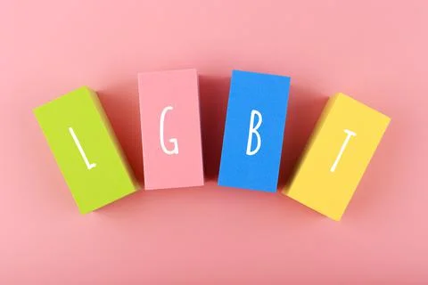 Lgbt letters on multicolored rectangular geometric figures on pink background. Fotos de archivo