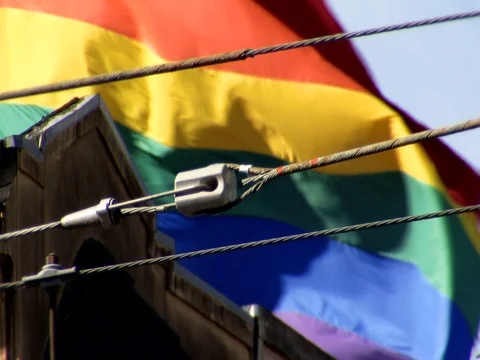 Lgbt pride flag flapping against blue sky daytime Stock Footage 89212524