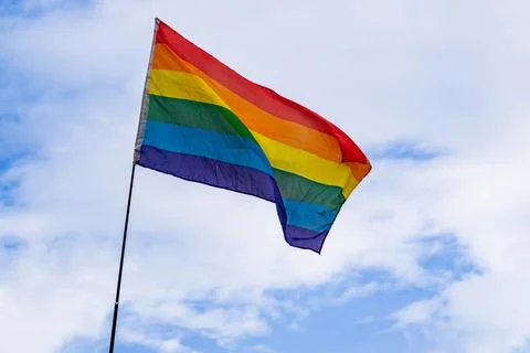 LGBTQ flag Low angle view of rainbow against a blue sky on a sunny day Stock Photos