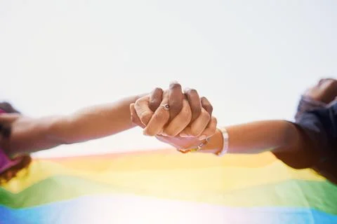 LGBTQ flag, rainbow and couple holding hands for gay pride, lesbian support or Stock Photos