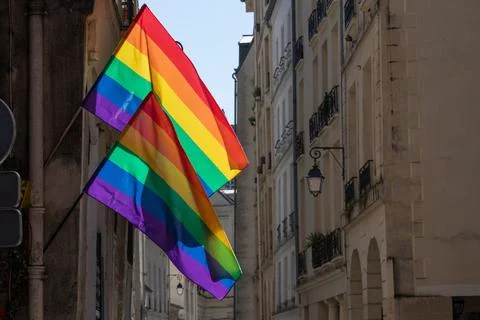 LGBTQ flags on corner of old building in Paris during pride. Transgender Pride Stock-Fotos