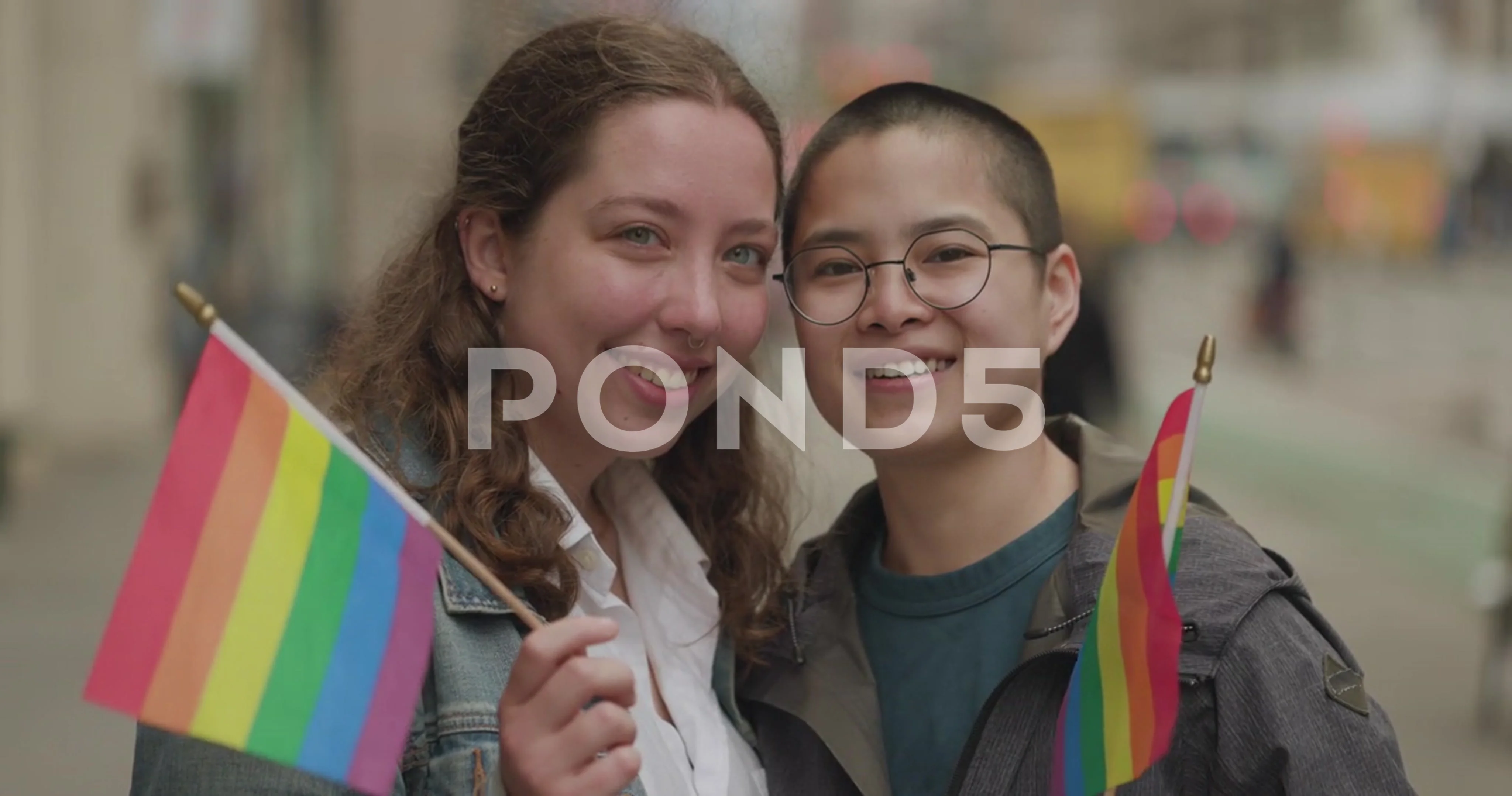 LGBTQ LGBT lesbian same sex couple on city street smiling happy