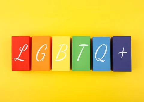 Lgbtq plus letters on rectangular geometric figures on yellow background. Fotos de archivo